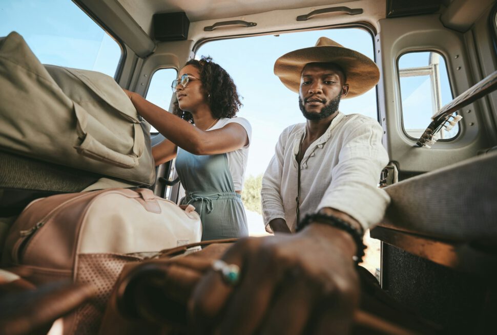Travel luggage, black couple and car road trip together love bonding on nature safari holiday in Af